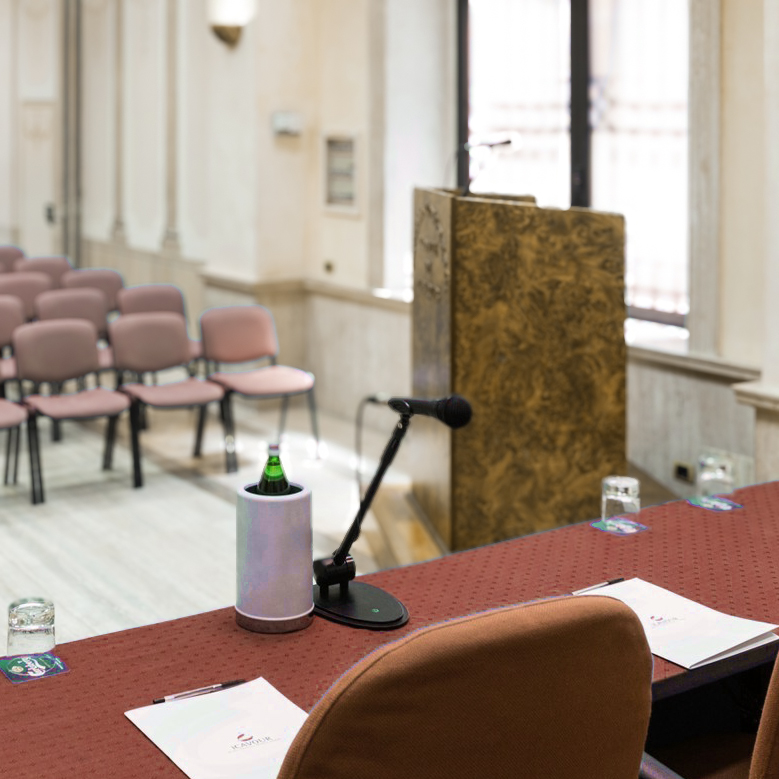 Convegno culturale con pubblico e relatori seduti al tavolo